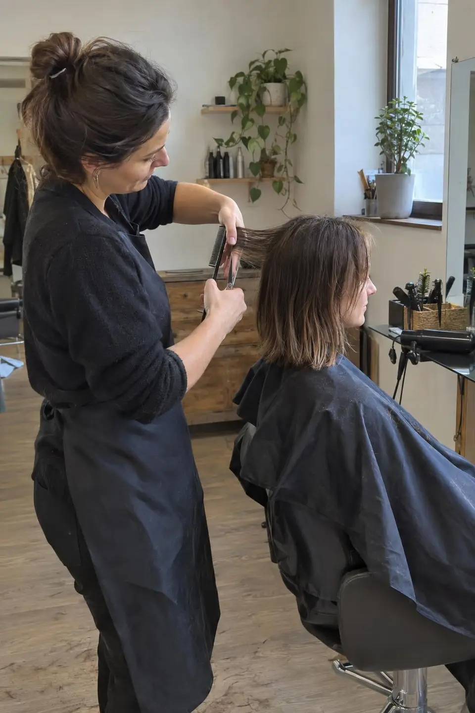 Frizerka striže stranko s srednje dolgimi lasmi
